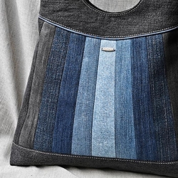 Ručně šitá kabelka z několika odstínů rifloviny. Jednotlivé části předního dílu jsou sešity patchworkovou technikou, stylizované do duhy. Základní díl je všitý do sedla, které je ozdobeno modrou výpustkou. Zadní díl je ušitý z černé džínoviny a opatřen naš